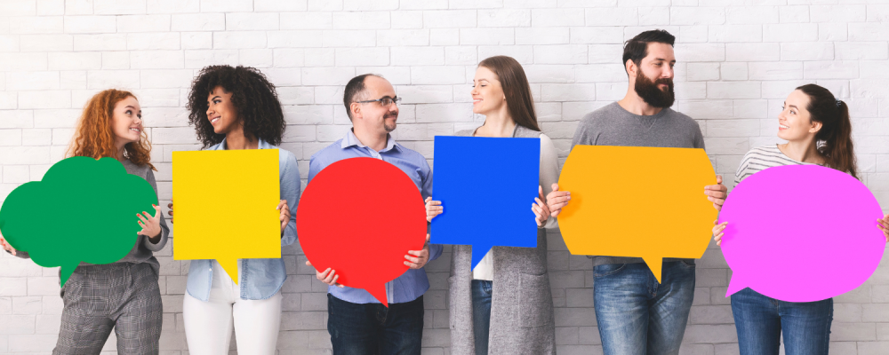 People having a friendly exchange and holding bright coloured dialog balloons